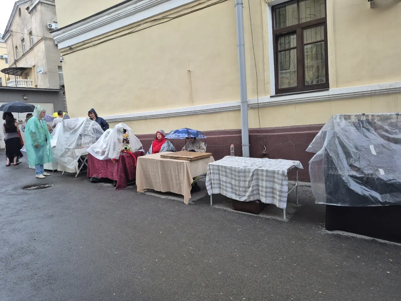 На открытой площадке разразился ливень: выставленная армейская техника и экспонаты промокли, посетители прятались под навесами и надевали дождевики.