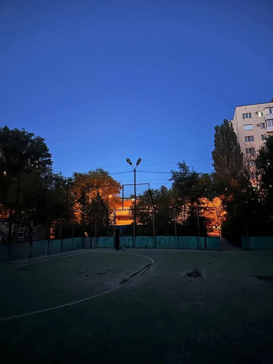 Во дворе на улице Титова спортивная площадка давно осталась без света. Жильцы обращаются к управляющей компании и администрации с просьбой восстановить освещение — площадка регулярно используется для игр и соревнований.