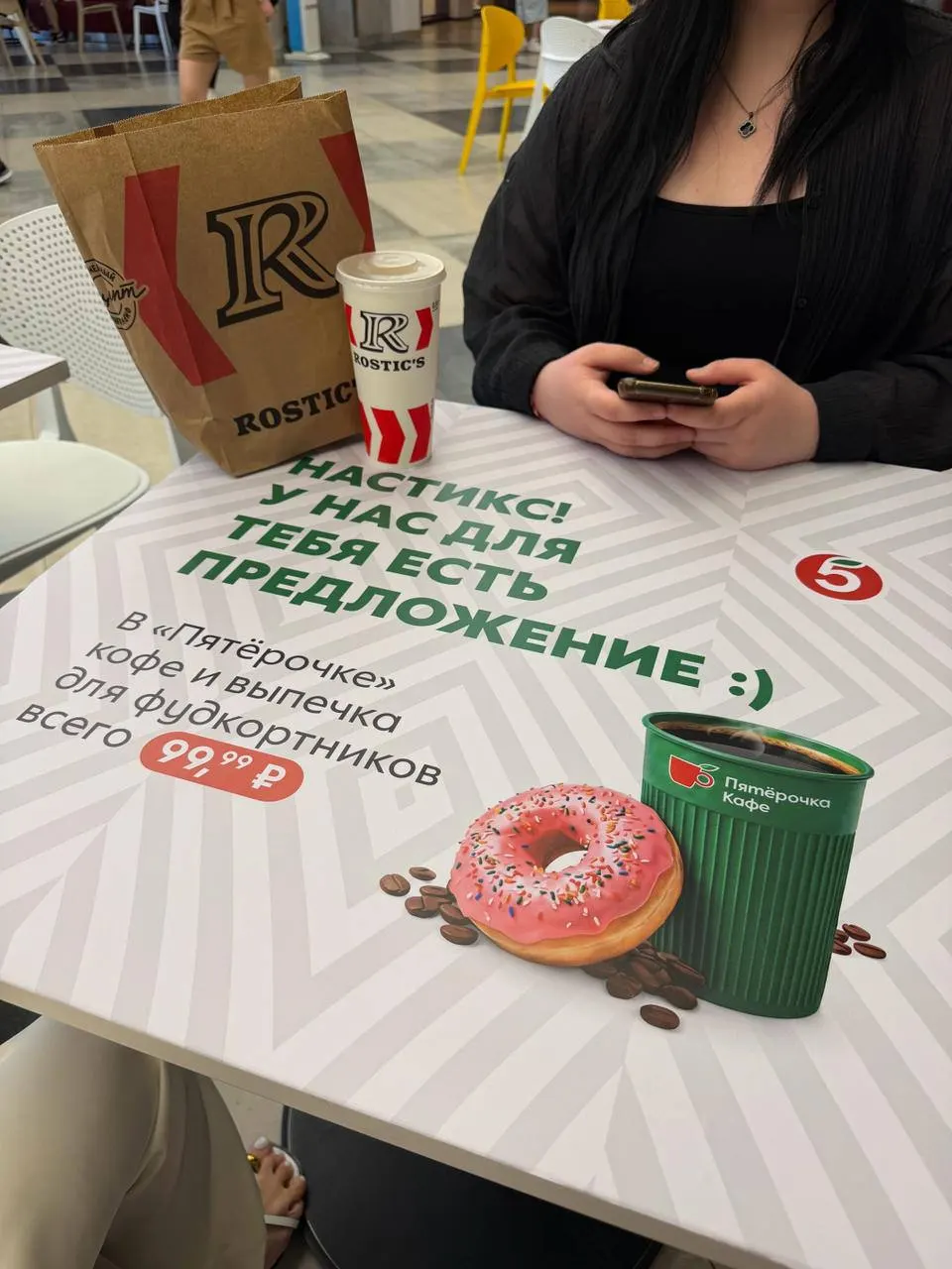 Сеть наклеила стикеры на столы фудкорта в «Галерее», блогеры заметили это и начали снимать ролики — теперь магазин превращается в новую точку встреч.