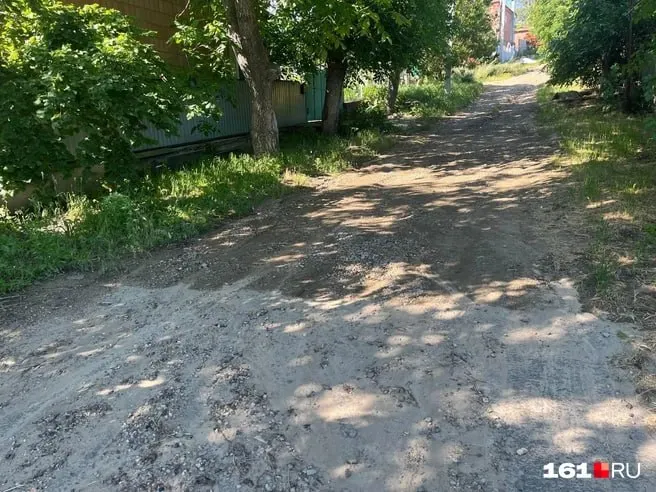 В Мясниковском районе часть улицы Набережной заасфальтировали в 2025 году, но во время дождя с выше лежащих участков стекает грязь и камни — отремонтированный участок разрушается и поток доходит до остановки.