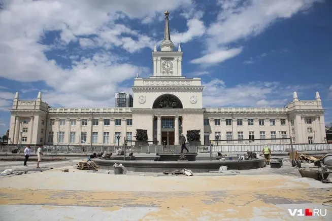 Перед главным входом железнодорожного вокзала укладывают плитку и прокладывают поливочный водопровод для будущих зелёных насаждений. Пока на площади мало тени, но уже установлен обновлённый фонтан «Детский хоровод».