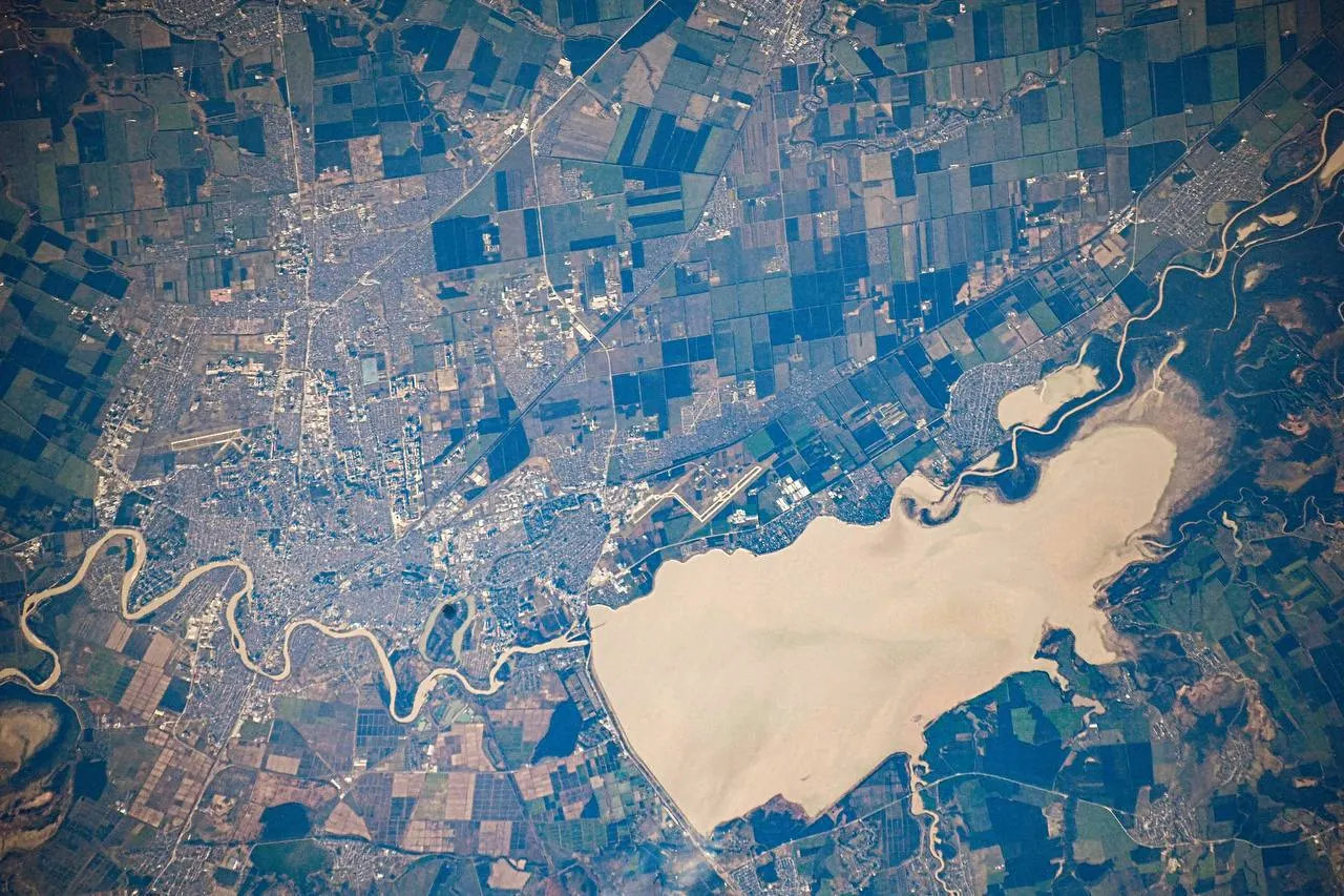 Снимок Краснодара с МКС демонстрирует городские кварталы, Кубанскую реку и водохранилище; в кадр попала часть территории Республики Адыгея.