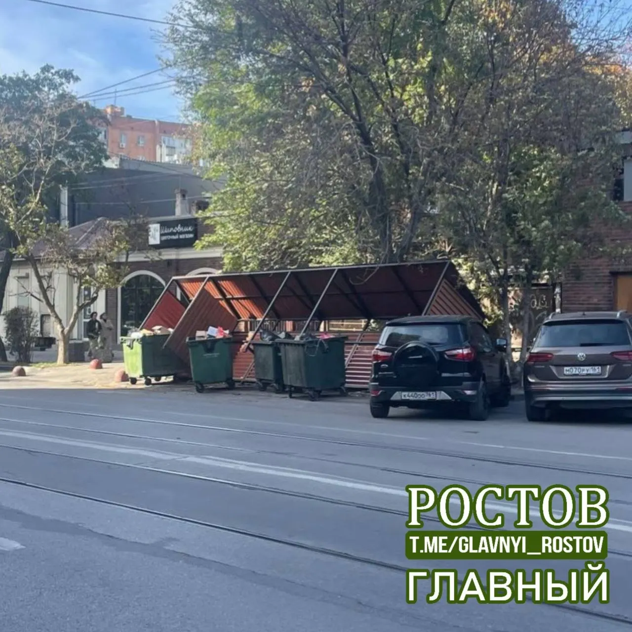 Сильный ветер повредил навес над мусорной площадкой прямо на проезжей части в районе улицы Горького, создавая опасную ситуацию на дороге.